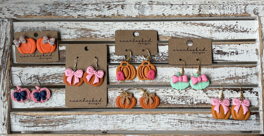 Handmade polymer clay pumpkin earrings in assorted fall styles, including orange, pink, and mint pumpkins with bows and classic designs, lightweight autumn jewelry by Everhooked