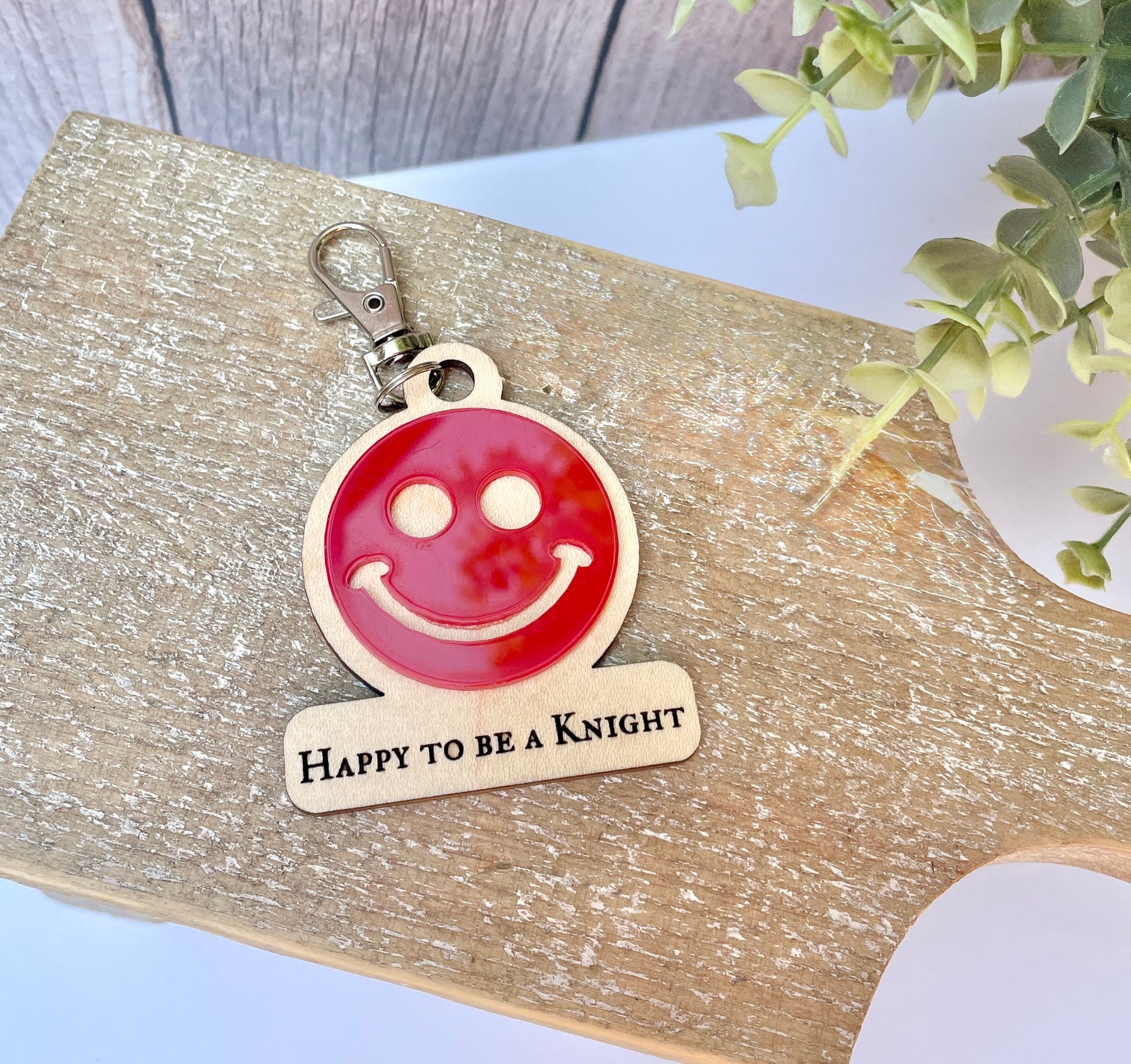 Happy to be a Knight engraved on maple plywood with a red acrylic smiley face layered on top.