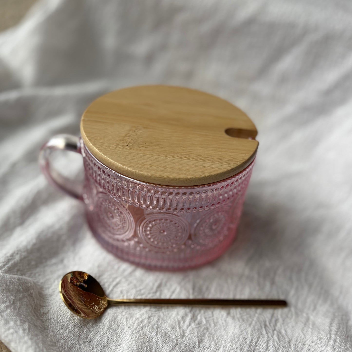 Pink embossed glass mug with bamboo lid and gold spoon