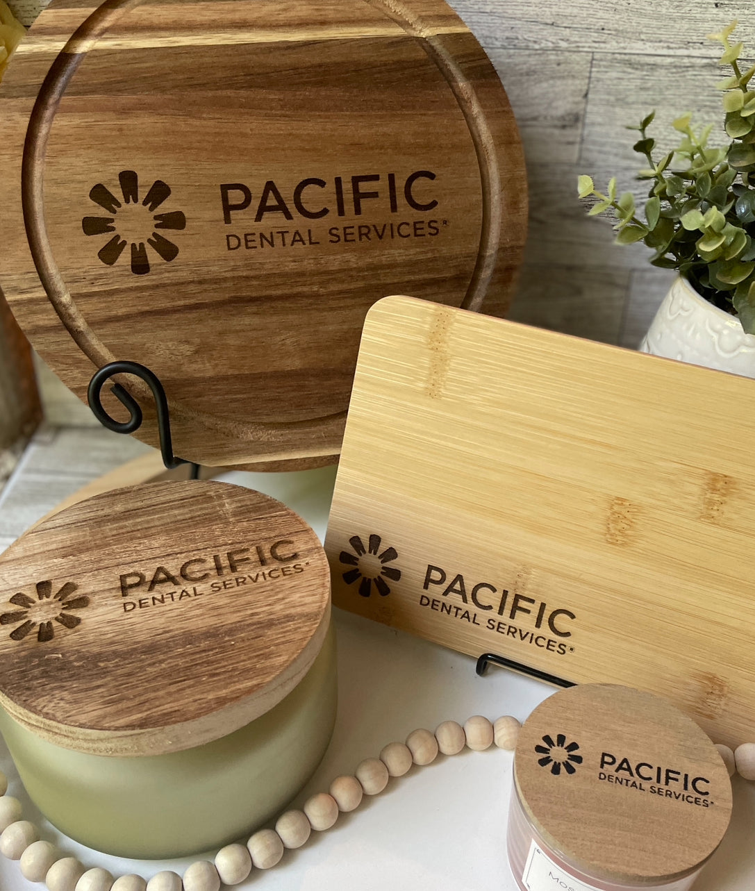A collection of candles and boards with Pacific Dental Services engraved on it