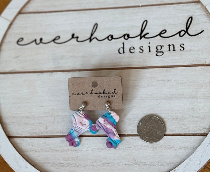 Pink Purple Blue Roller Skate Earrings next to quarter for size comparison