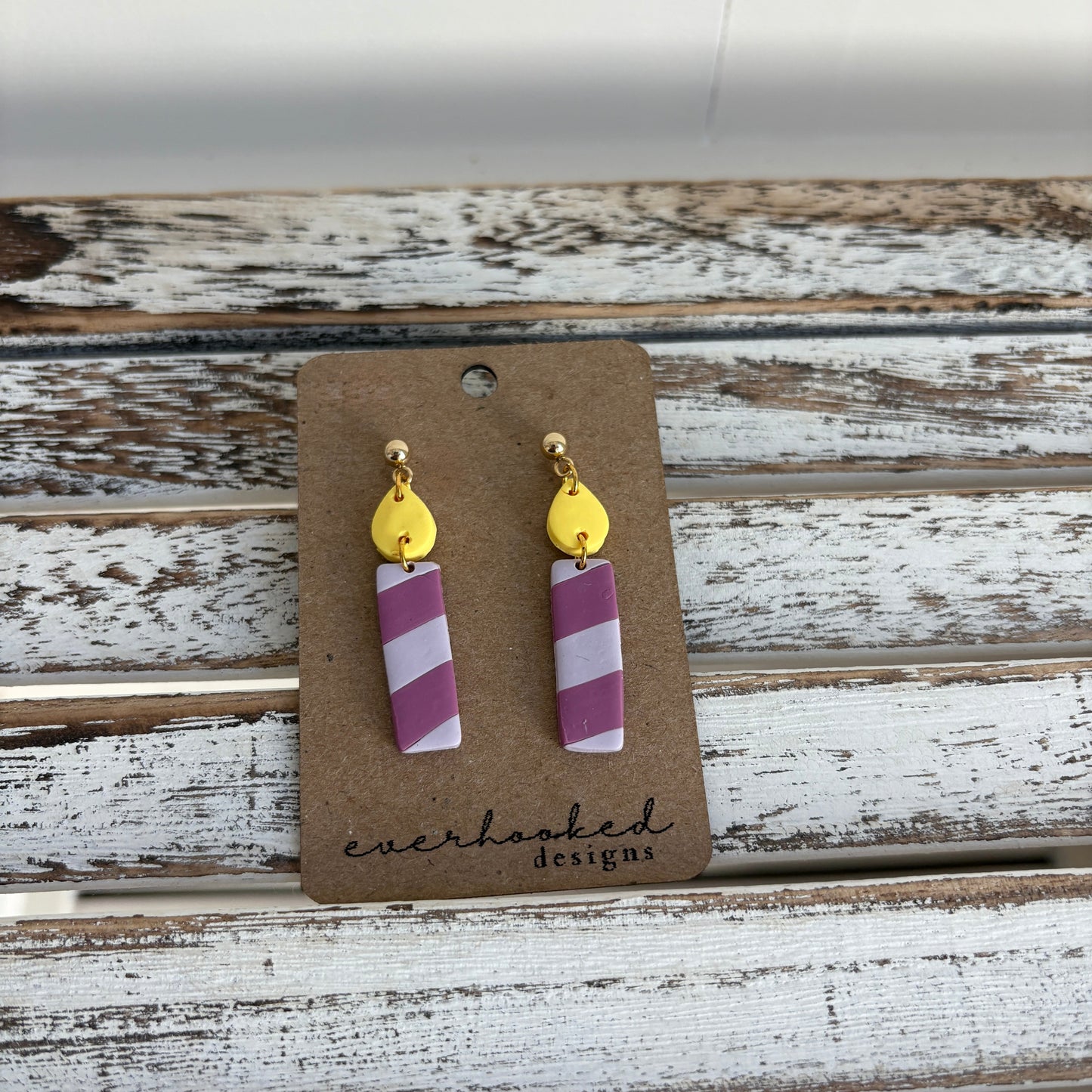 Purple and lavender clay candle earrings with attached yellow flame stud.