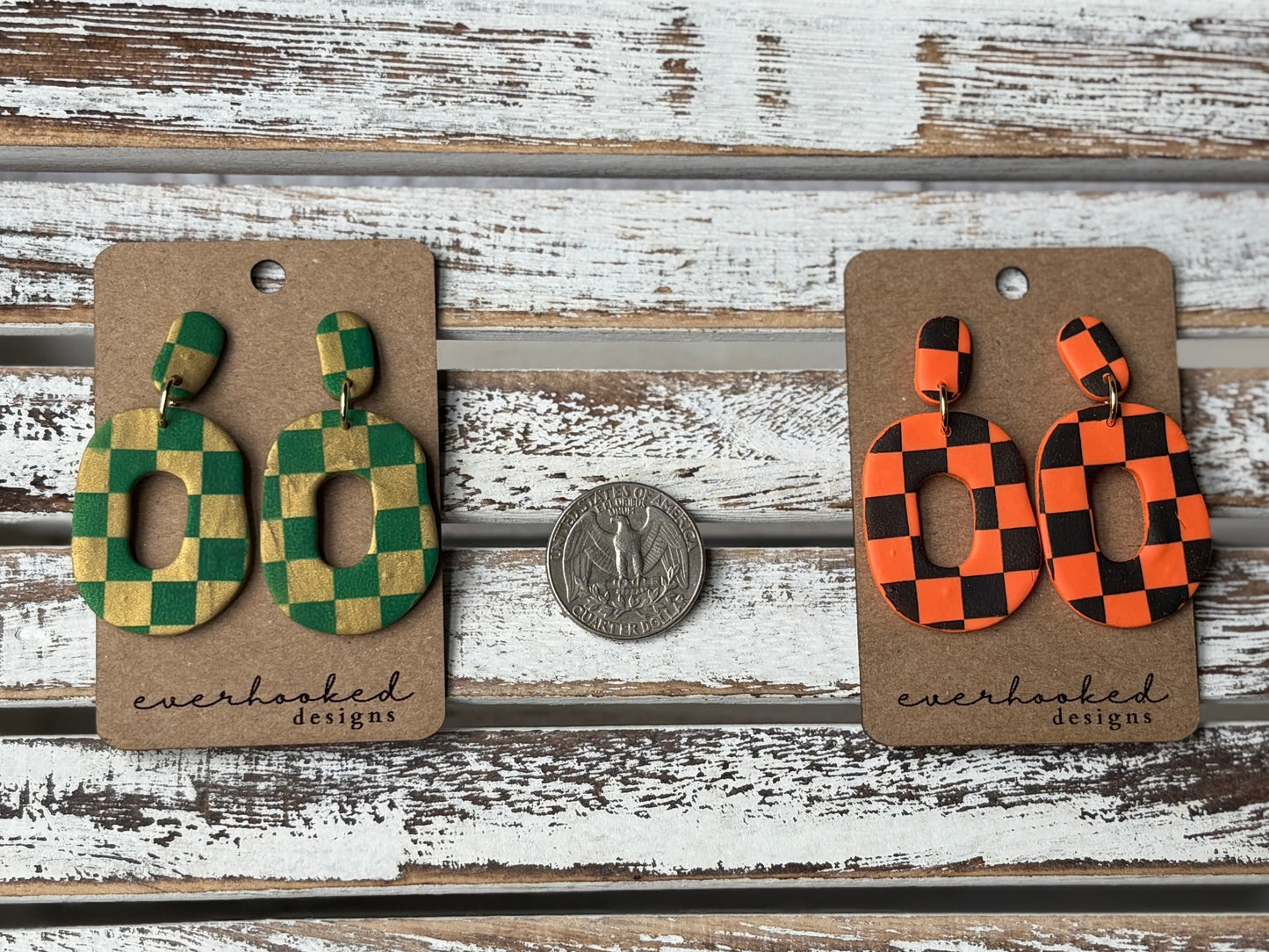 Green and gold and orange and black checkerboard clay earrings next to quarter for sizing