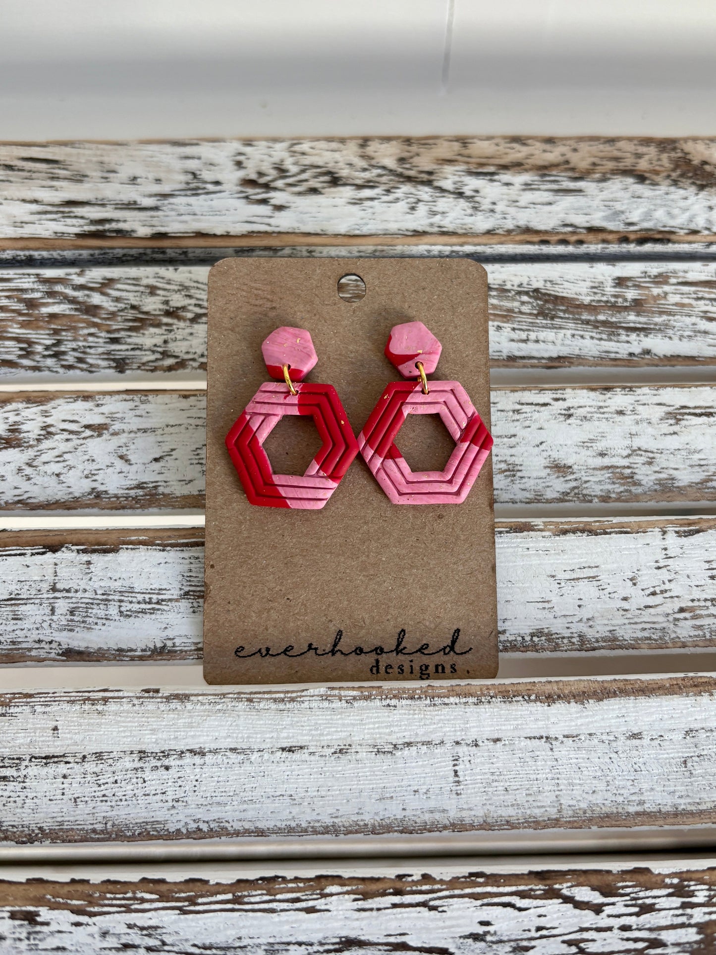 Modern polymer clay earrings with layered hexagonal shapes in a pink ombre design. Bold, geometric, and lightweight with gold-plated hardware.