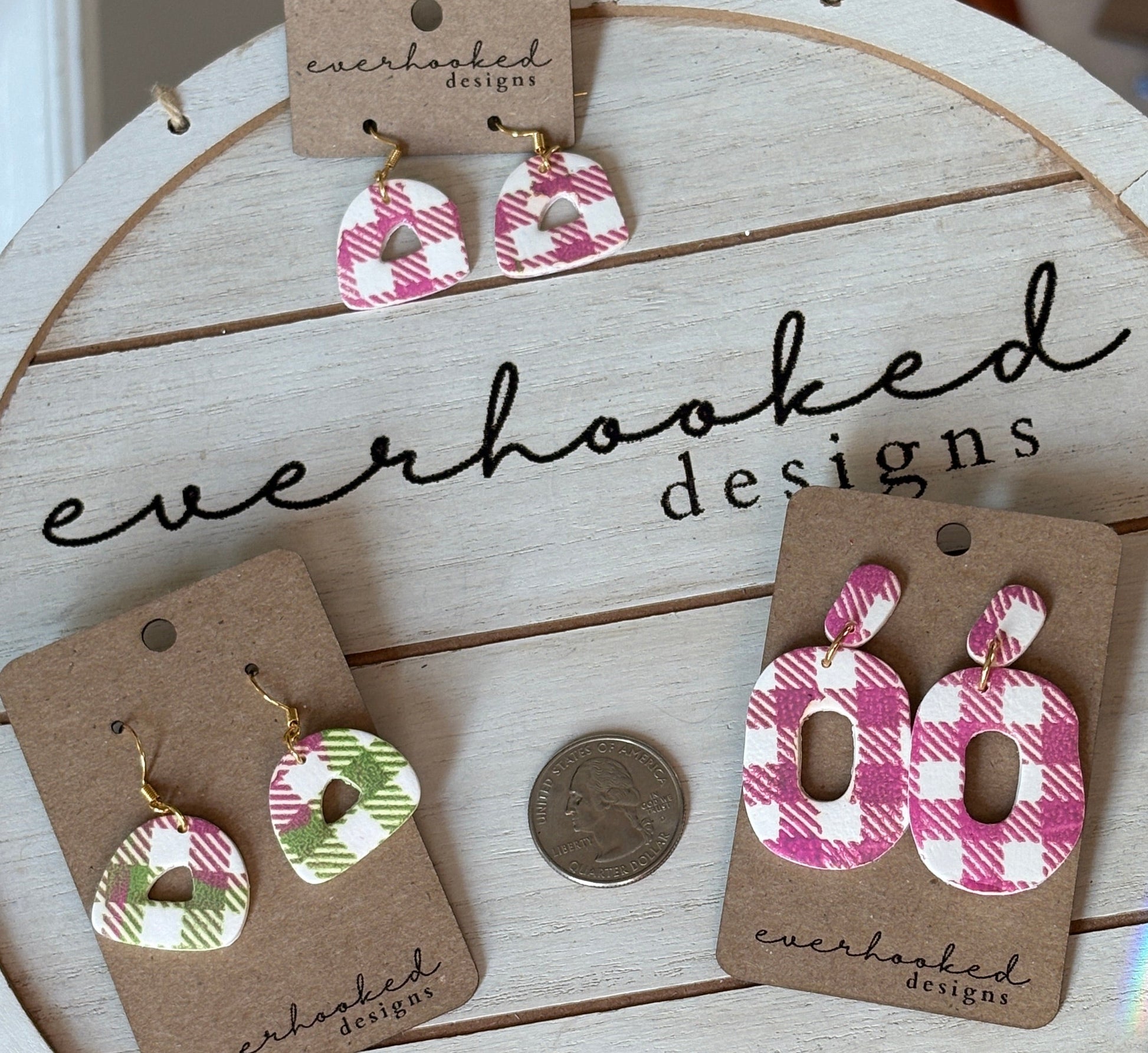 Three pairs of plaid dangly earrings pink and green