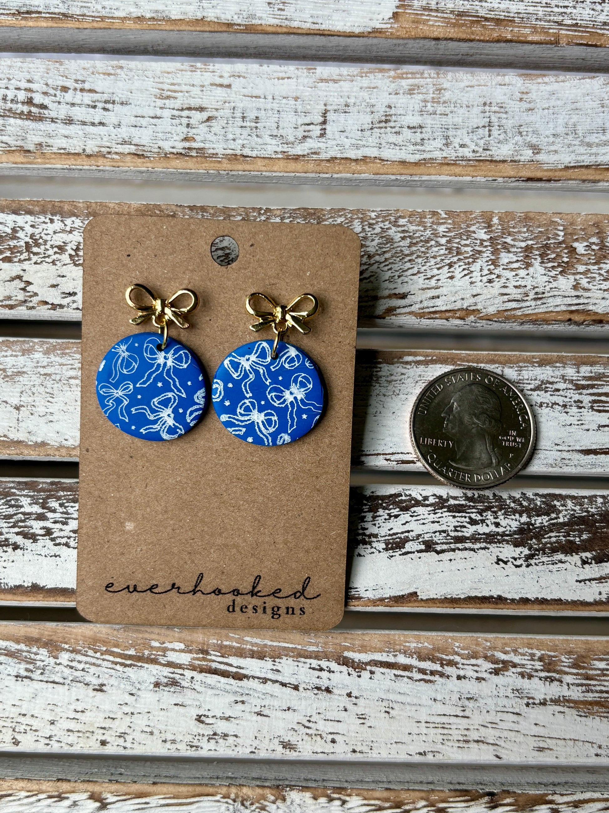 Round Blue earrings with bow design and gold bow hardware with coin to compare