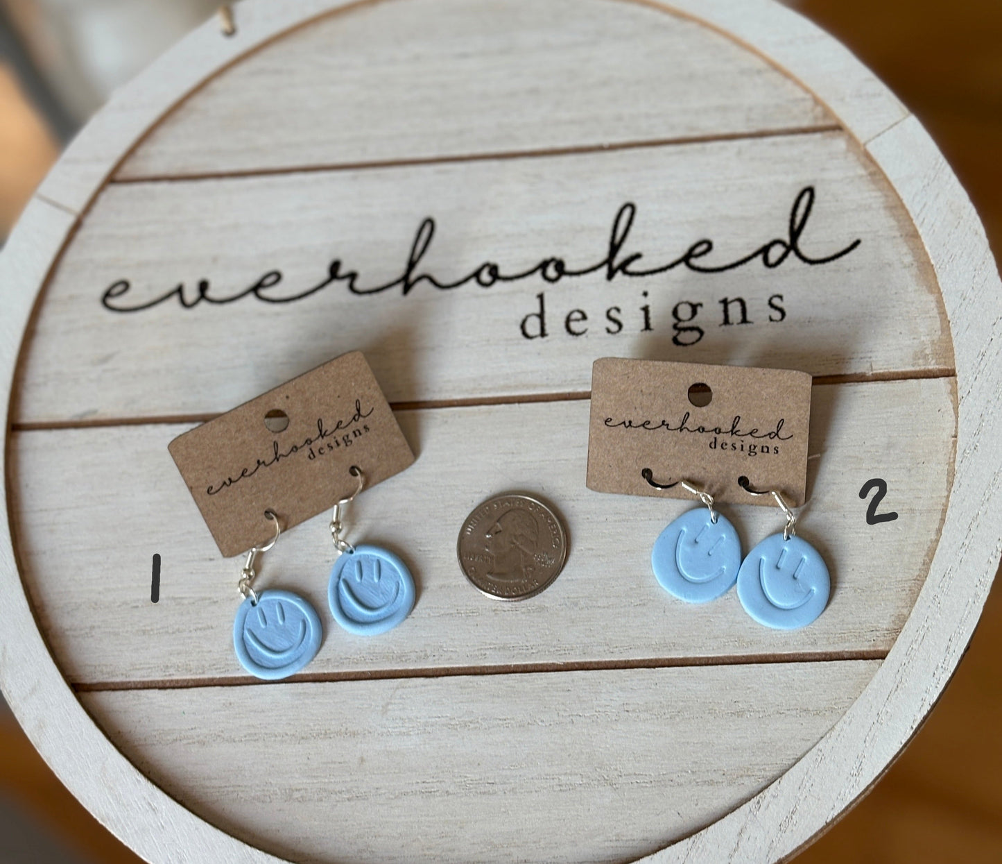 Light Blue Smiley Earrings next to a quarter for sizing