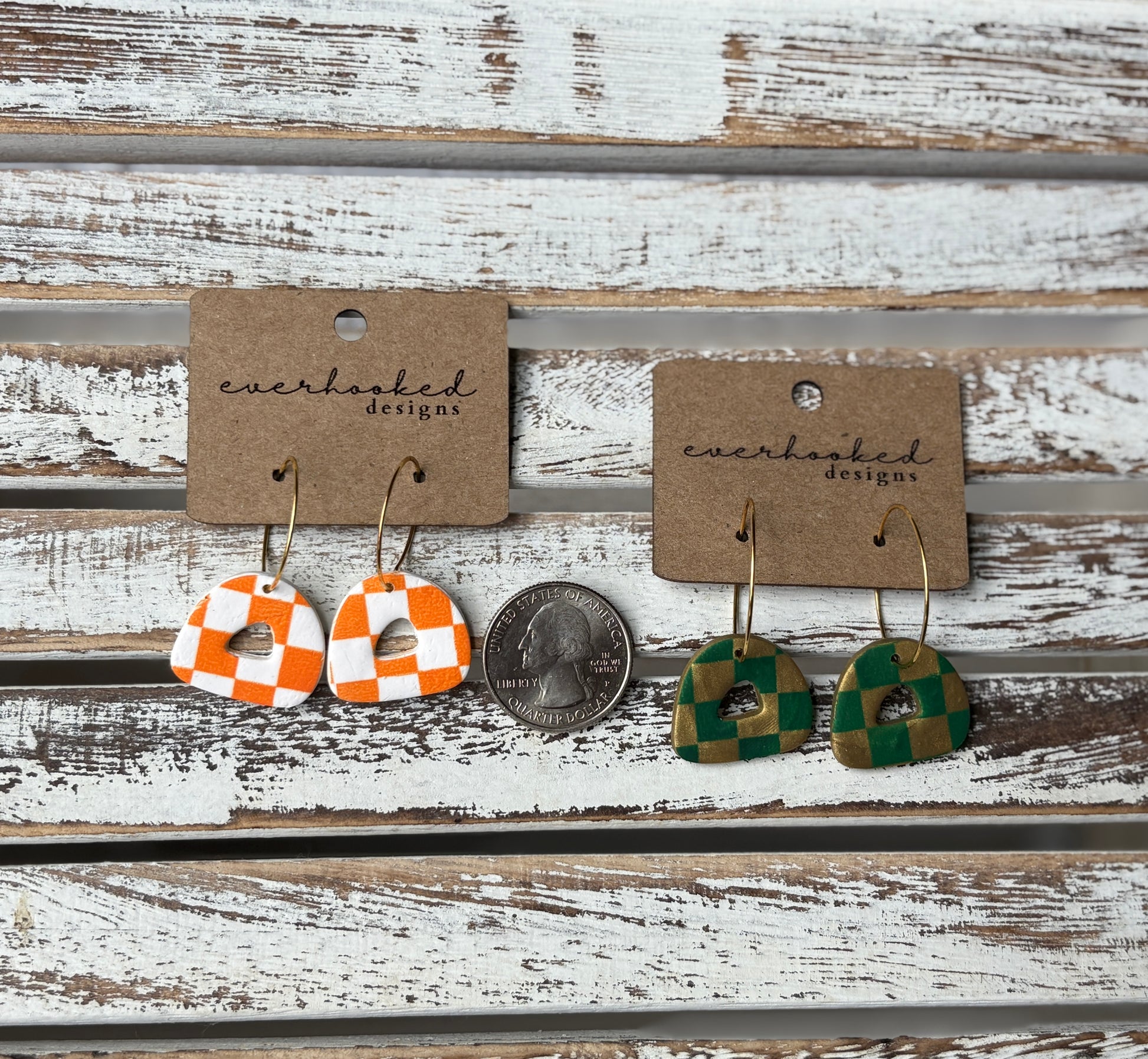 Two pairs of mini checkerboard clay earrings on kraft cards with gold hoops, shown with a quarter for size reference. Colors include orange and white, and green and gold.
