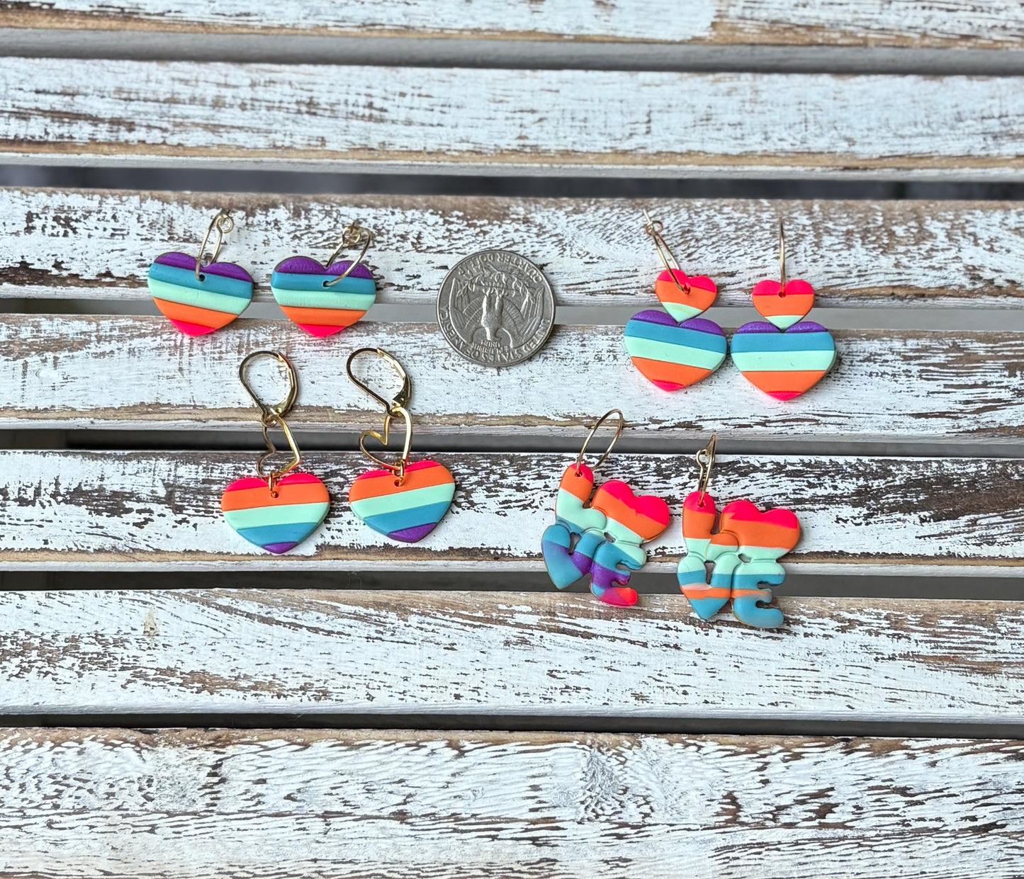 Close-up of rainbow heart dangles and LOVE clay earrings
